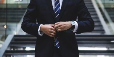 スーツのボタンを留める男性