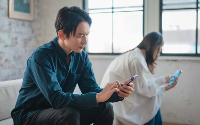 スマホを見ながら悩む男性と女性