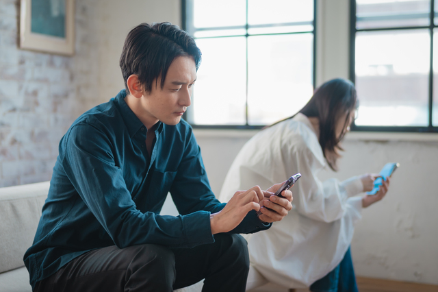 スマホを見ながら悩む男性と女性