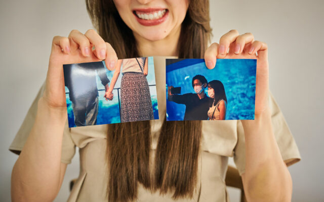 2つの写真を見せる女性