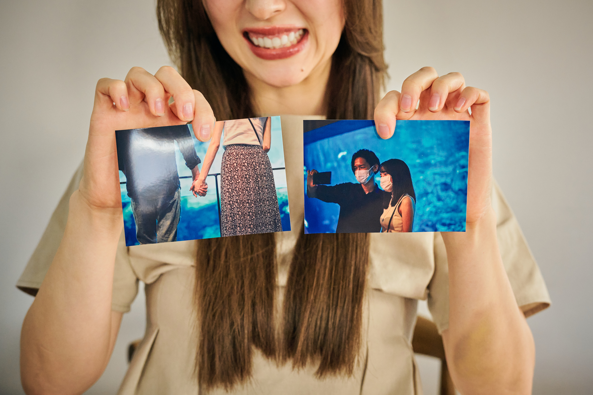 2つの写真を見せる女性