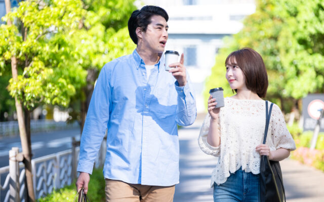 飲み物を片手にデートする男女