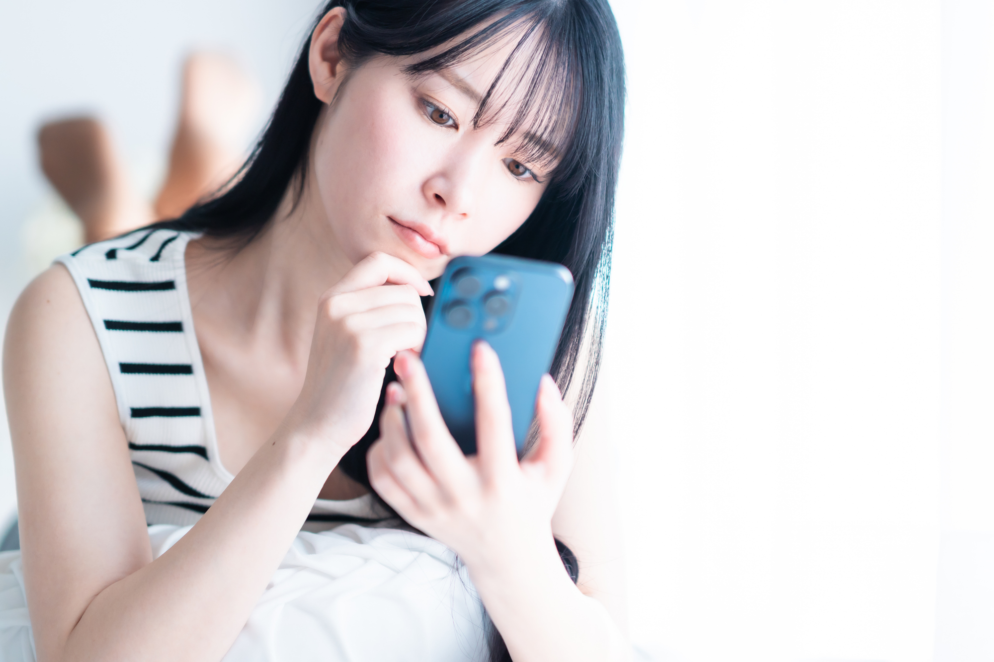 スマートフォンを持ち悩む女性