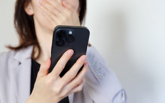 スマホを見て驚く女性