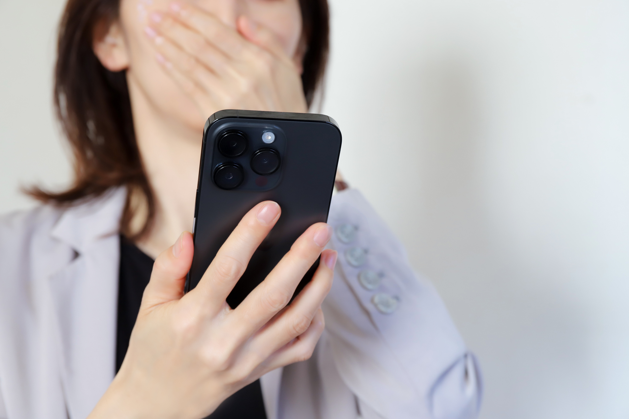 スマホを見て驚く女性