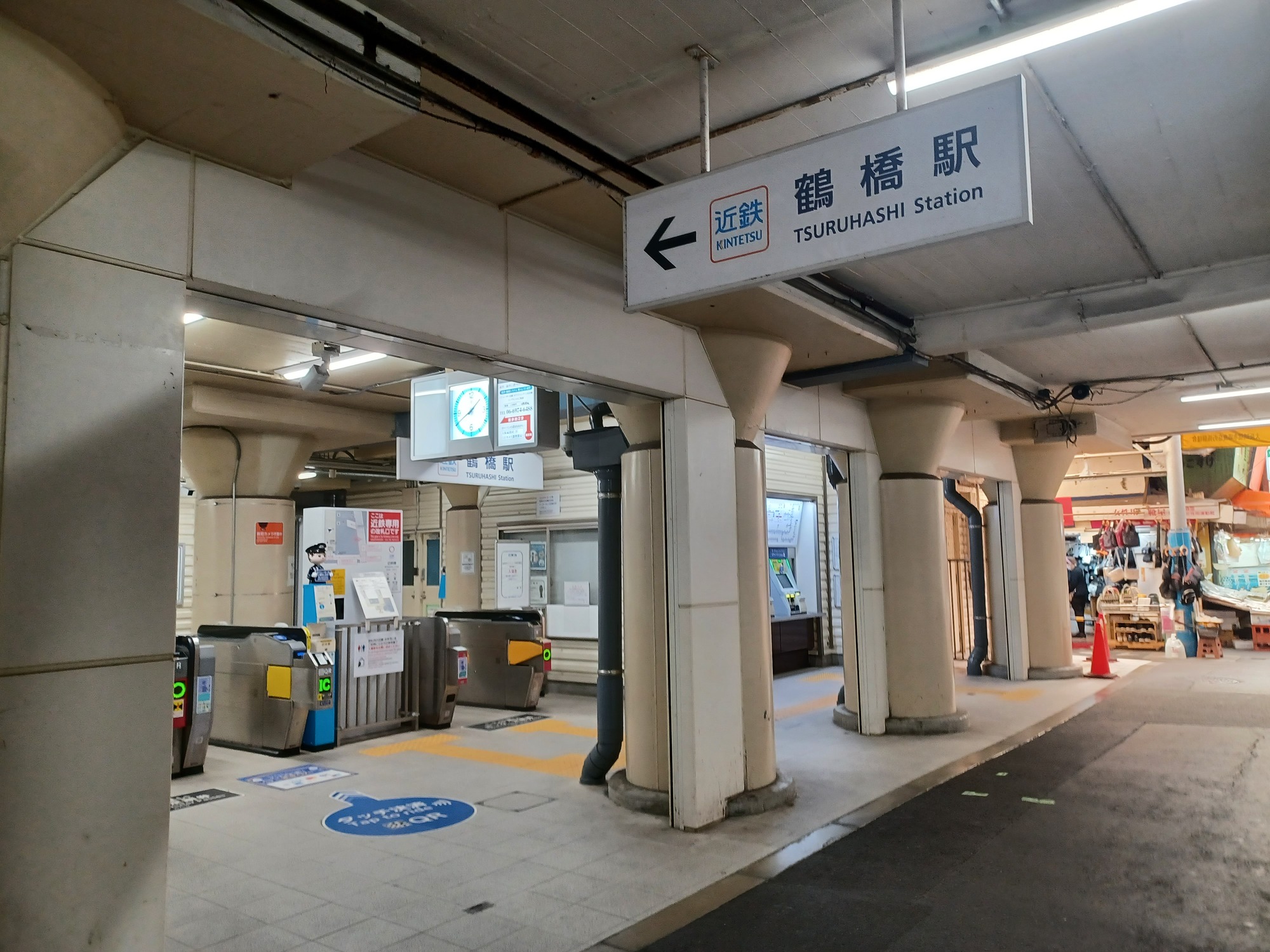 左側に改札口が見え、右奥に商店街が続く駅前通路