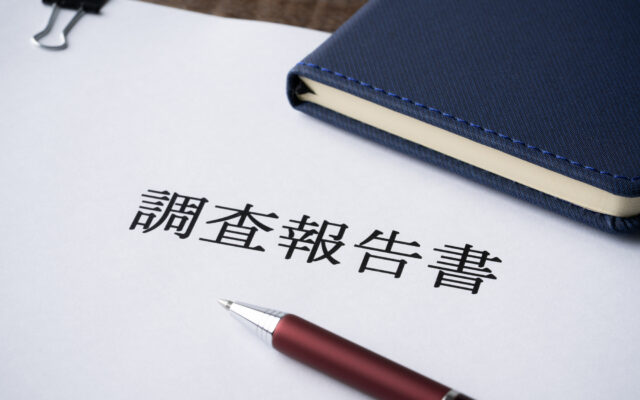 調査報告書と手帳とボールペンのクローズアップ