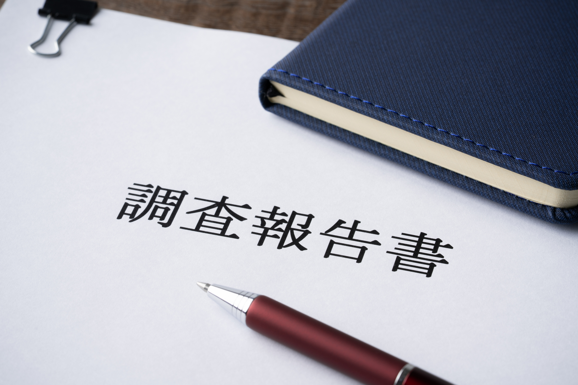 調査報告書と手帳とボールペンのクローズアップ