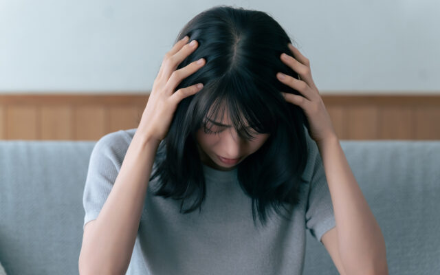 頭を抱えて悩む女性