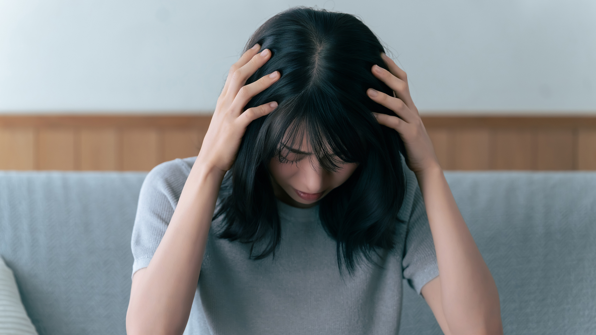 頭を抱えて悩む女性