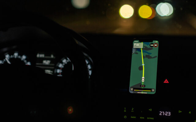 スマートフォンのナビアプリで道案内をしてもらいながら、暗闇の中を車で走っている