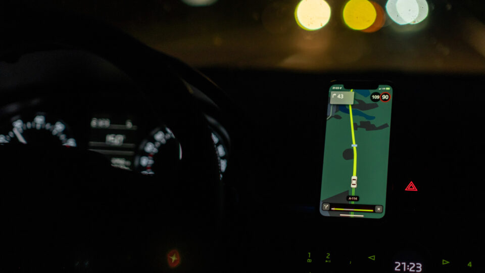 スマートフォンのナビアプリで道案内をしてもらいながら、暗闇の中を車で走っている